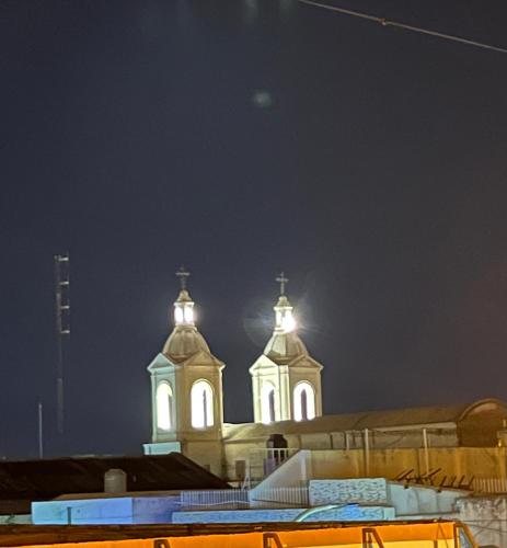 a church with two towers lit up at night at Casa feliza in Villa Dolores