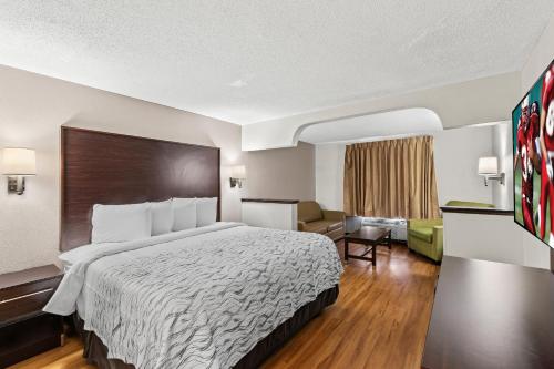 a hotel room with a bed and a living room at Red Roof PLUS+ & Suites Atlanta Airport South in Atlanta