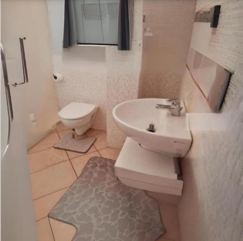 un bagno bianco con lavandino e WC di Alba Sweet ad Alba Adriatica