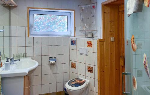 a bathroom with a toilet and a sink and a window at Ferienwohnung Lychen in Lychen
