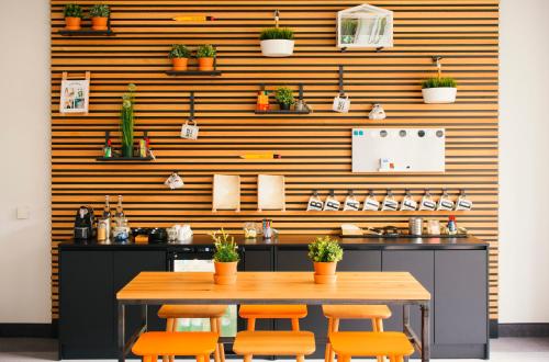 a kitchen with a wooden table and orange chairs at Vienna House Easy by Wyndham Landsberg in Landsberg am Lech