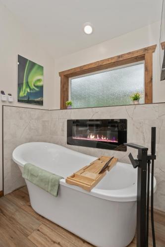 y baño con bañera y chimenea. en Lazy Mountain Guest House, en Palmer