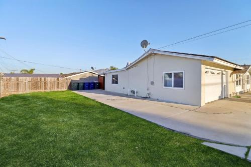 a white house with a fence in a yard at Entire Private 2-Bedroom Home w Gated Yard, Driveway Parking, Available Now in Spring Valley