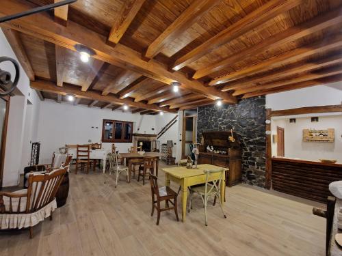 a living room with wooden ceilings and tables and chairs at C'era una volta b&b in Santo Stefano dʼAveto