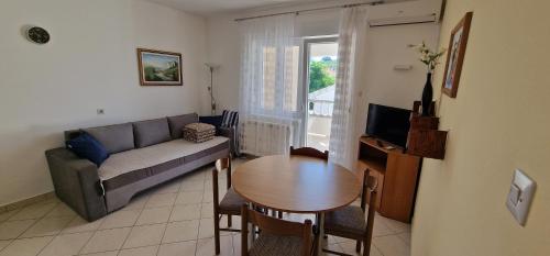 un soggiorno con un divano e un tavolo di Apartmani Neda a Rab