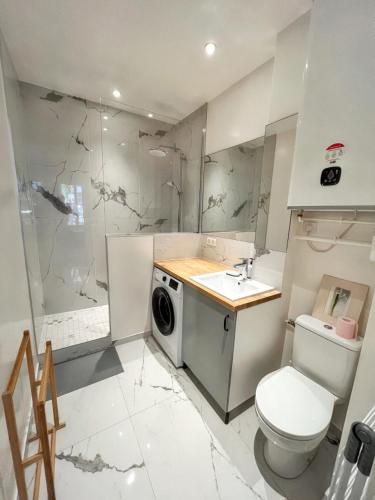 a bathroom with a washing machine and a sink at Studio de charme à Montrouge - 20 m² - Internet inclus in Montrouge