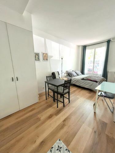 a living room with a table and a bed at Studio de charme à Montrouge - 20 m² - Internet inclus in Montrouge