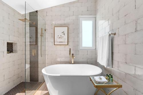 a white bathroom with a tub and a shower at Olive Villa Palmas - Modern Beachfront in Humacao