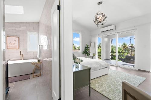 a bedroom with a tub and a bed and a sink at Olive Villa Palmas - Modern Beachfront in Humacao