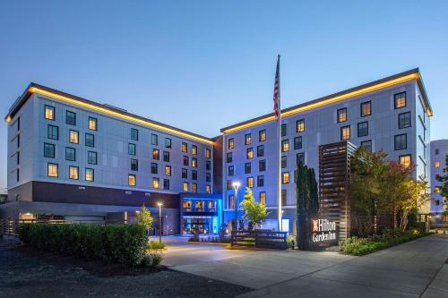 a large building with a flag on top of it at Hilton Garden Inn Redmond WA in Redmond