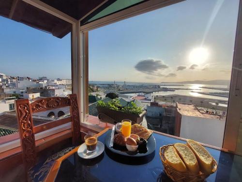 a plate of food on a table on a balcony at Mamora Bay in Tangier