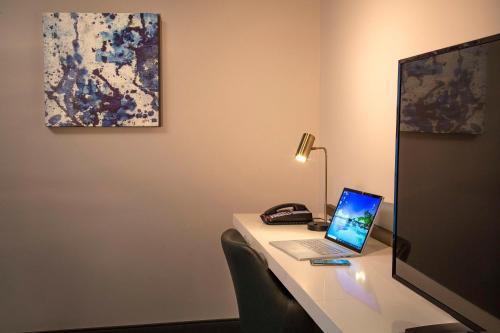 a desk with a laptop computer and a phone at Hilton Garden Inn Redmond WA in Redmond