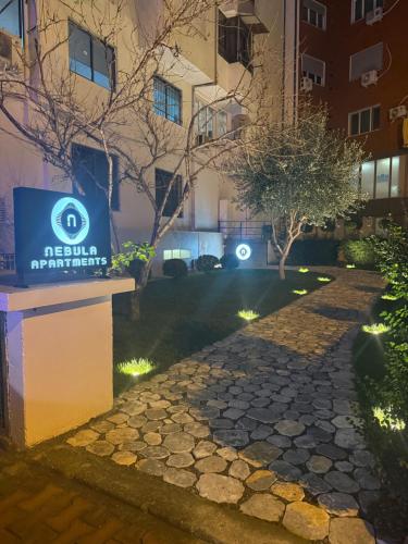 a walkway in front of a building at night at Nebula Apartments in Tirana