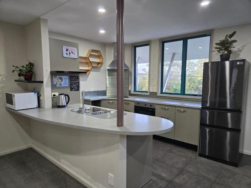 - une cuisine avec un grand comptoir et un réfrigérateur dans l'établissement Parkhill Apartment in CBD, à Whangarei