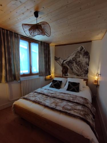 une chambre avec un grand lit et deux fenêtres dans l'établissement La Terrasse des Ecrins, à Saint-Martin-de-Queyrières