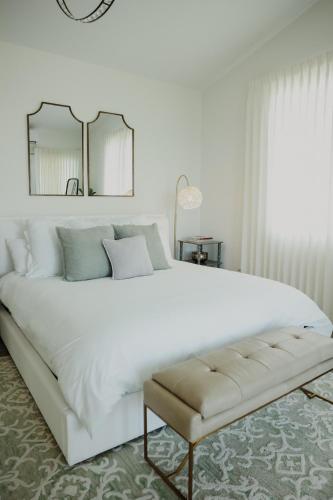 a white bedroom with a large bed and a mirror at Olive Villa Palmas - Modern Beachfront in Humacao