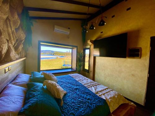 a bedroom with a bed in a room with a window at Cabañas Leufü Lodge con Tinaja in Valdivia