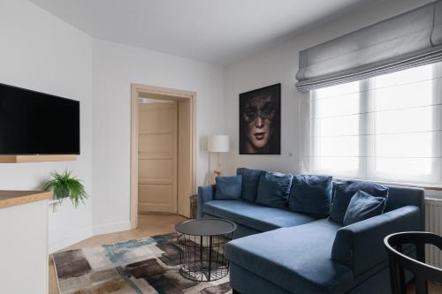 a living room with a blue couch and a tv at Apartament w Sopocie MEWA - przestronny - blisko plazy by Lion Apartments Sopot in Sopot