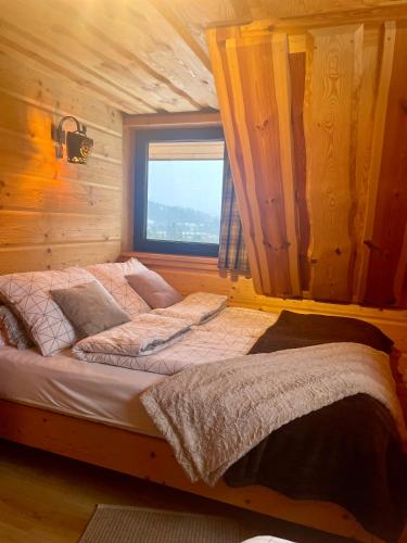 a large bed in a room with a window at Wypas Hills - domek na wyłączność in Białka Tatrzańska
