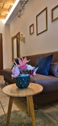 a vase of flowers on a table in a living room at Dida's House Aeroporto BGY in Urgnano