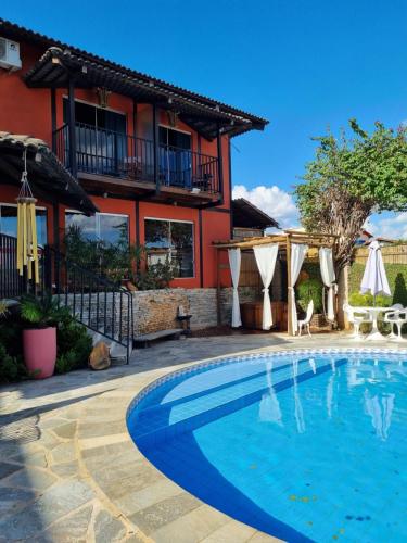 a swimming pool in front of a house at Pousada Ikabana in Pirenópolis