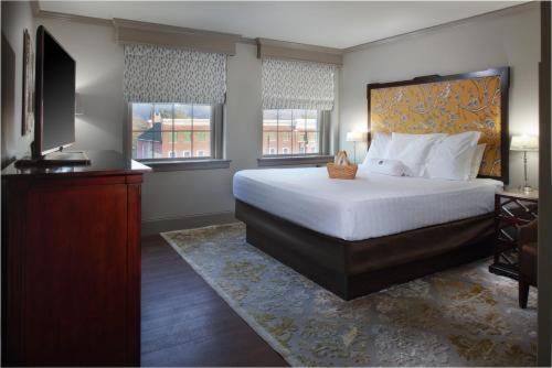 a bedroom with a large bed and a television at The Bolling Wilson Hotel in Wytheville