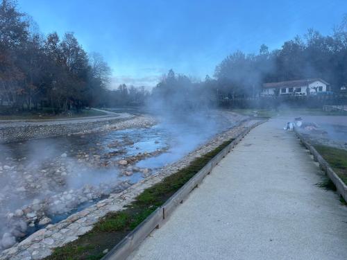 a stream of smoke next to a river with a house at Casa da Lage - Vistas rio - Gerês in Geres
