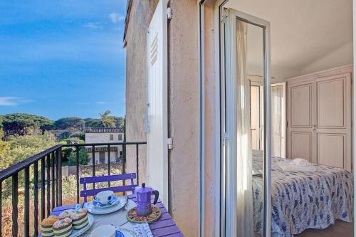 d'un balcon avec une table et des assiettes de nourriture. dans l'établissement Studio Les Jardins du Pinet - Happy Rentals, à Saint-Tropez