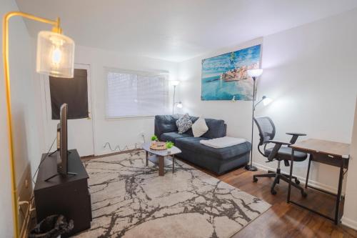 een woonkamer met een bank en een bureau bij APT Near Hospital,UofM,EMU in Ypsilanti