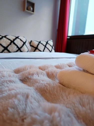 - un lit blanc fermé avec 2 chaises dans l'établissement Chamonix : Studio intime au bord du lac des Gaillands et pistes de ski, à Chamonix-Mont-Blanc