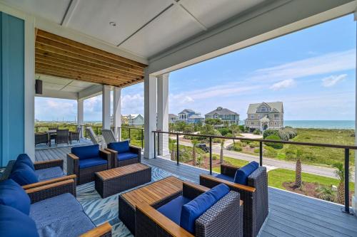Un porche con sofás y sillas y vista al océano. en Panoramic Ocean Views - Private Pool - Pickleball Court - Luxury Design Build, en North Topsail Beach