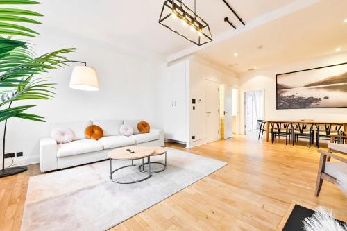 a living room with a white couch and a table at Amazing 3 Bed Apartment Great Portland Street in London