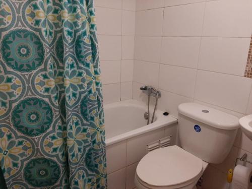 ein Badezimmer mit Toilette und Duschvorhang in der Unterkunft Departamento portal del mar in La Serena