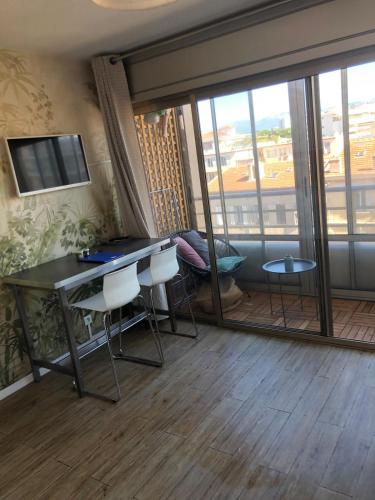 Cette chambre dispose d'un bureau, de chaises et d'une grande fenêtre. dans l'établissement Studio and breakfast, à Cannes