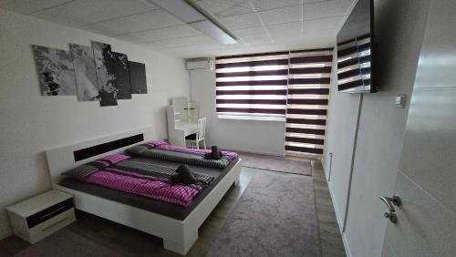 a bedroom with a bed with purple sheets and a window at Stan na dan Bosanska Krupa in Bosanska Krupa