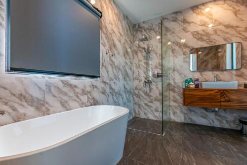 a bathroom with a tub and a sink at Scenic Lamai Getaway in Amphoe Koh Samui