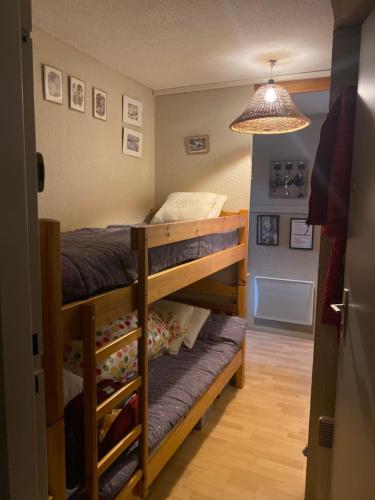 - une chambre avec deux lits superposés et une lumière dans l'établissement Les blanches aiguilles, aux Carroz d'Arâches