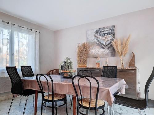 une salle à manger avec une table et des chaises dans l'établissement Maison tout confort avec jardin, à 1km de la plage, à Saint-Hilaire-de-Riez