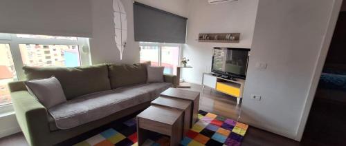 a living room with a couch and a tv at Modern Mountain View P&E Tirana Apartment Netflix included in Tirana