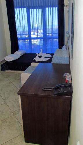 a hotel room with two beds and a desk at Afrodita Hotel in Sinemorets