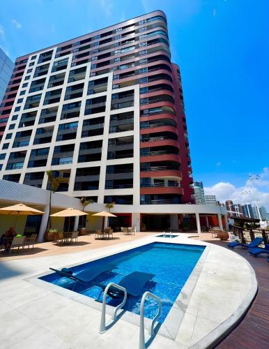 a large building with a swimming pool in front of a building at Flat Iate in Fortaleza
