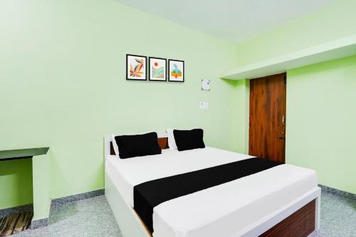 a bedroom with a white bed with black and green walls at Hotel O Royal Midlaans in Kālapettai