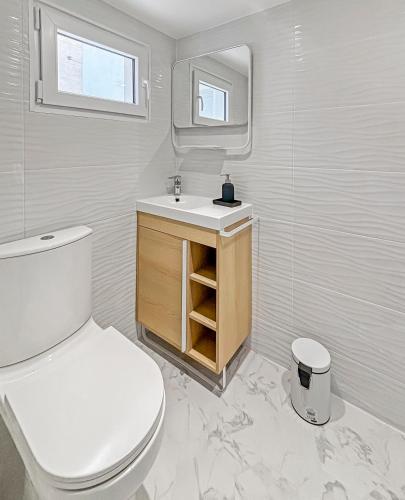 une salle de bain avec toilettes, lavabo et miroir dans l'établissement Charmante dépendance avec jardin partagé, à Eaubonne