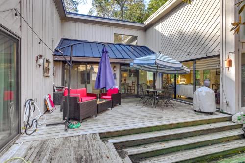 an outdoor deck with a table and an umbrella at 2 Mi to Beach Hilton Head Home with Furnished Deck in Hilton Head Island