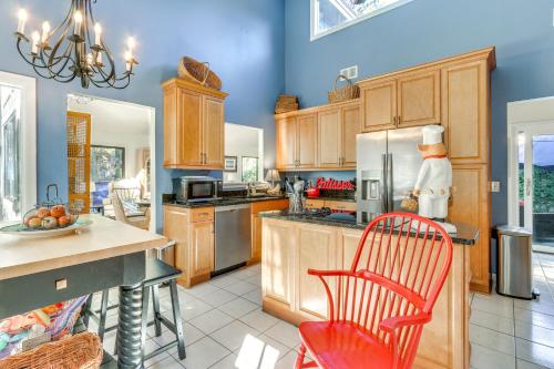 a large kitchen with wooden cabinets and red chairs at 2 Mi to Beach Hilton Head Home with Furnished Deck in Hilton Head Island
