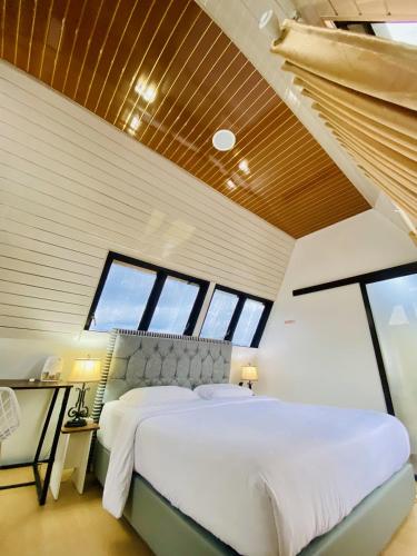 a bedroom with a large bed in a room with windows at Villa Eliana Wailan Tomohon in Tomohon