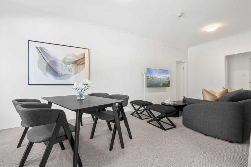 a living room with a couch and a table and chairs at Camperdown Cozy Corner 1 in Sydney