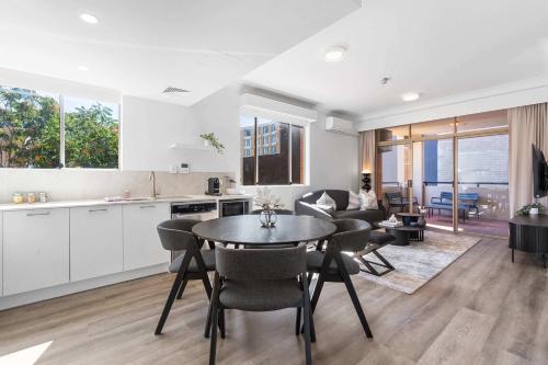 a kitchen and living room with a table and chairs at Camperdown Cozy Corner 3 in Sydney