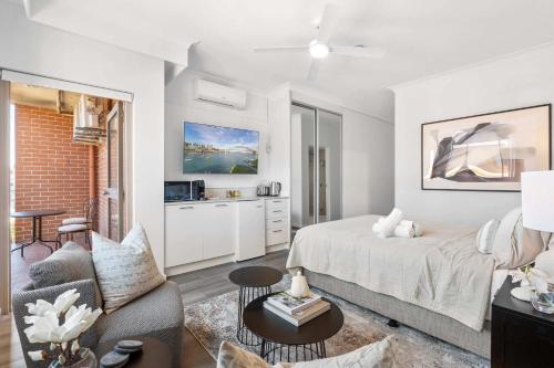 a bedroom with a bed and a living room at Camperdown Cozy Corner 4 in Sydney