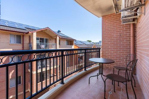 a balcony with two chairs and a table on it at Camperdown Cozy Corner 4 in Sydney